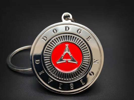 Round silver metal Dodge keychain with "DODGE DIVISION" text around a red and silver crest featuring the Fratzog logo.