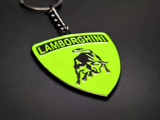 Shield-shaped verde and black Lamborghini metal keychain with a black bull logo and the "Lamborghini" wordmark.