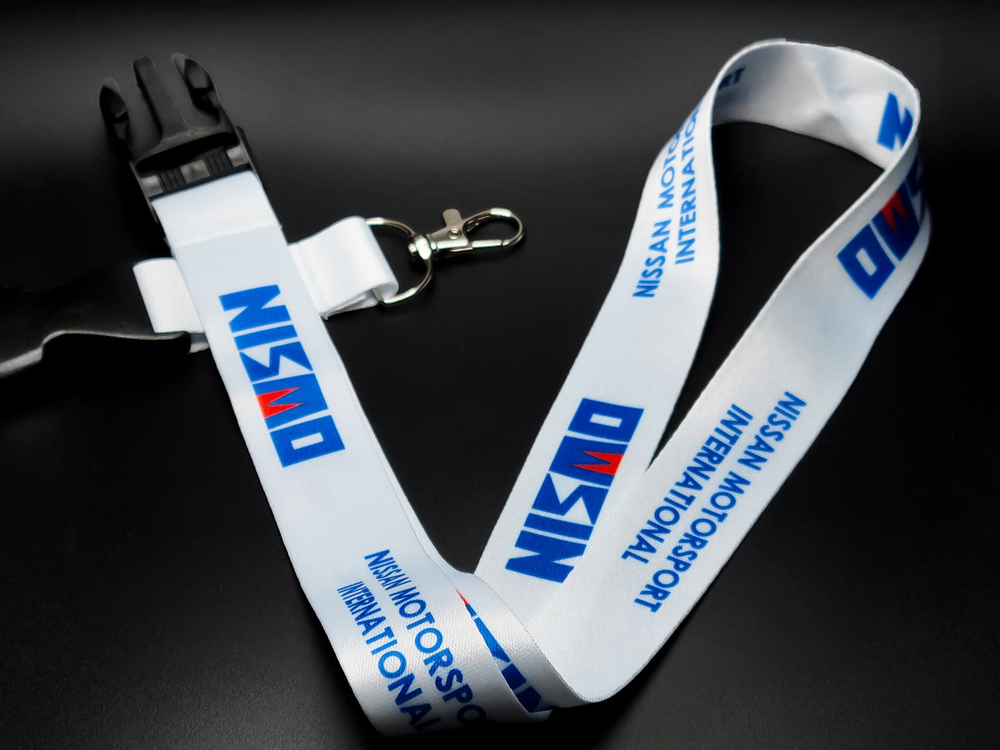Full layout of a Nissan Nismo JDM lanyard with its black plastic detachable buckle and durable silver lobster claw attachment for keys.