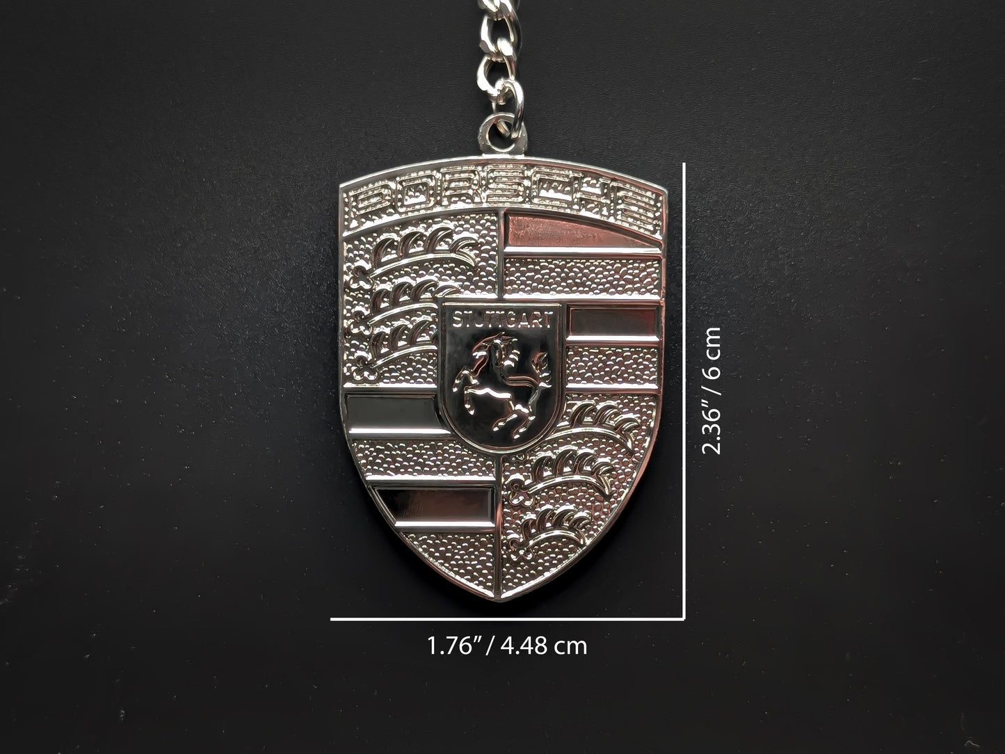 Dimensions of the Porsche silver badge keychain showing a size of 2.36 inches by 1.76 inches (6 cm by 4.48 cm).