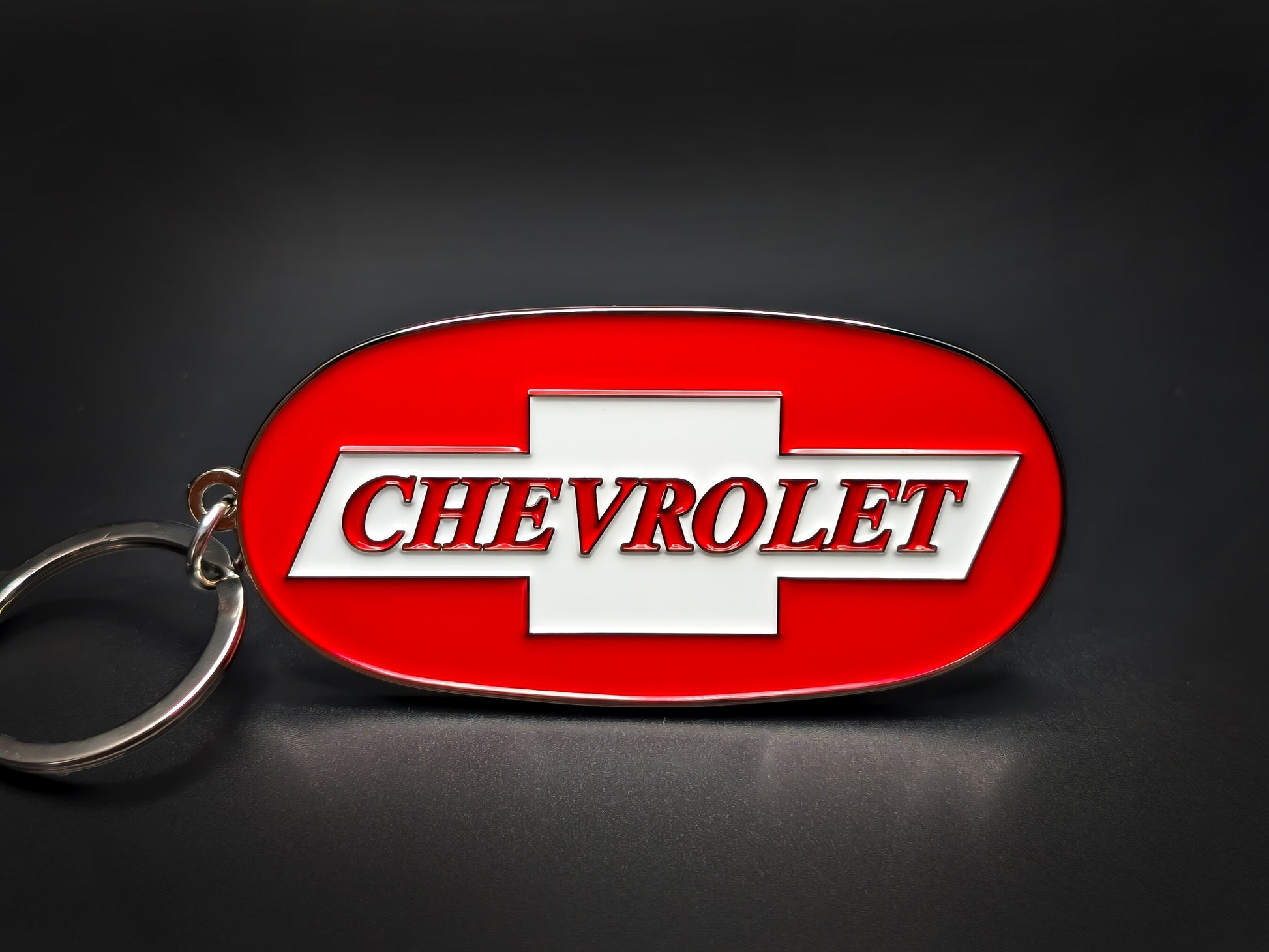 Oval red and silver Chevrolet double-sided metal keychain with the white bowtie logo and "CHEVROLET" text in red outline.