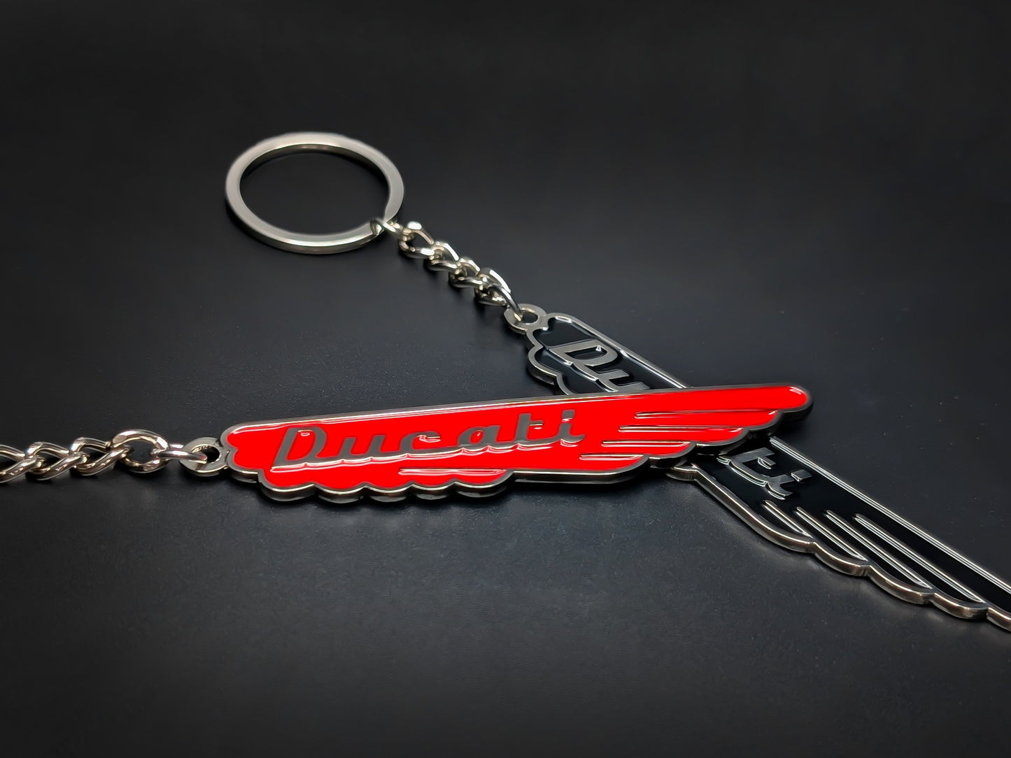 Red and black Ducati wings metal keychain with classic script.