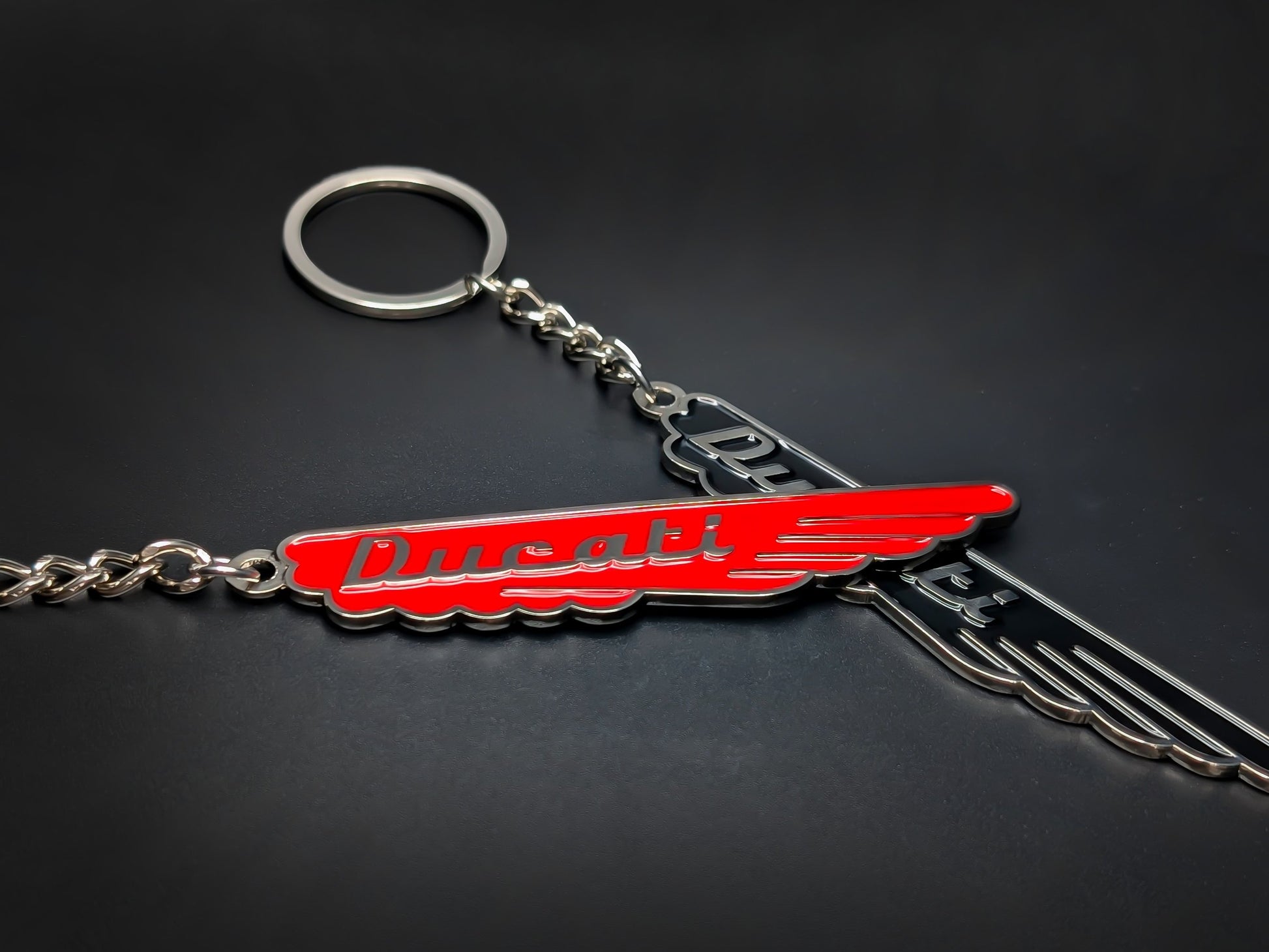 Red and black Ducati wings metal keychain with classic script.