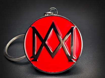 Round red and silver Aston Martin keychain with a large "M" shaped logo in the center.
