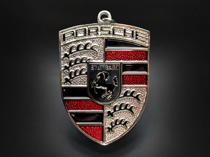 Silver and red Porsche shield metal keychain with red accents, "STUTTGART" text, and the horse emblem.