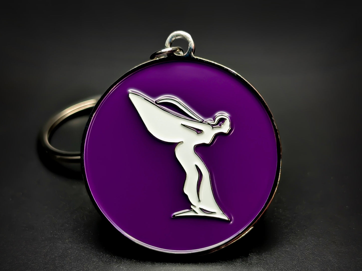 Round purple and silver Rolls-Royce keychain with a white "Spirit of Ecstasy" flying lady logo.