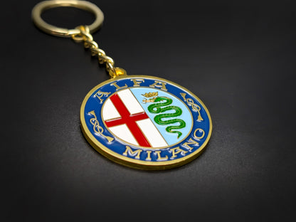 High-quality Alfa Romeo Milano heritage badge keychain on a dark background, showcasing the polished gold finish and linked chain.