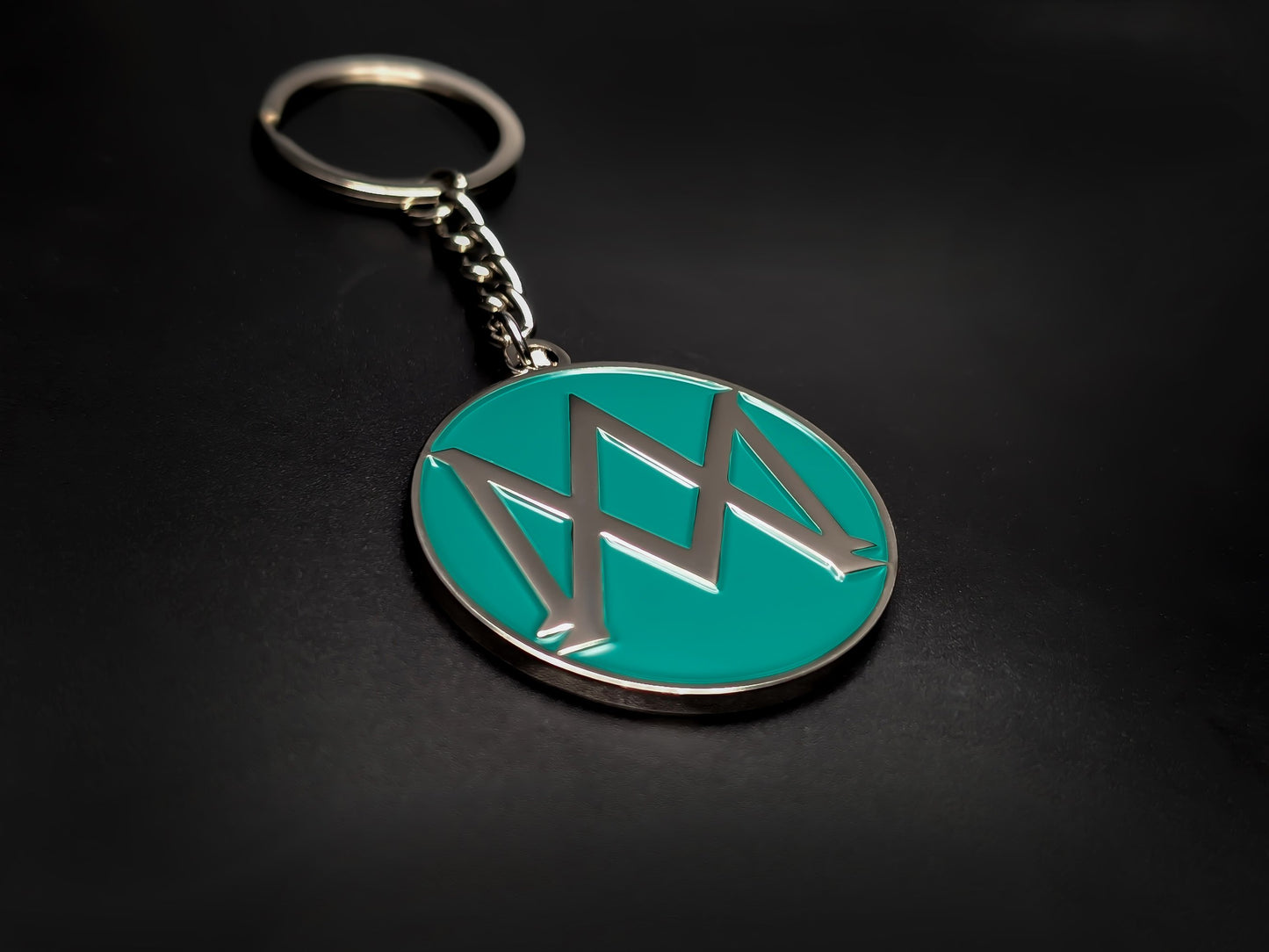 High-quality Aston Martin heritage keychain on a dark background, showcasing the polished silver-tone finish and durable linked chain.