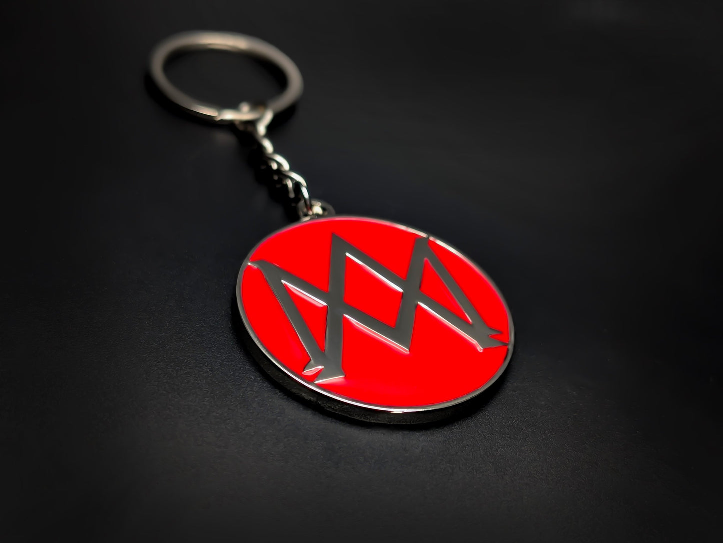 High-quality Aston Martin heritage keychain on a dark background, showcasing the polished silver-tone finish and durable linked chain.