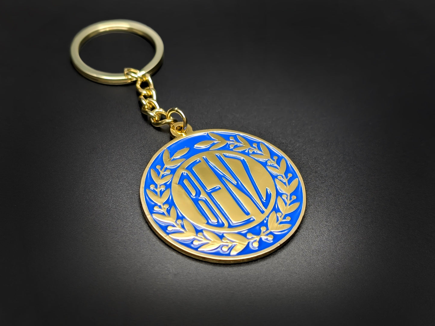 High-quality retro Benz heritage keychain on a dark background, showcasing the polished gold-tone metal and linked chain.