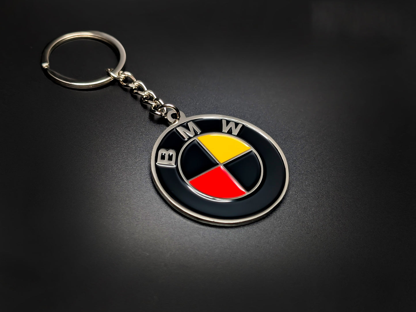 High-quality BMW German heritage keychain on a dark background, showing the glossy enamel finish and sturdy silver link chain.