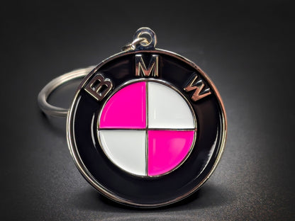 BMW roundel badge keychain featuring hot pink and white quadrants with polished silver-tone "BMW" lettering on a black outer ring.