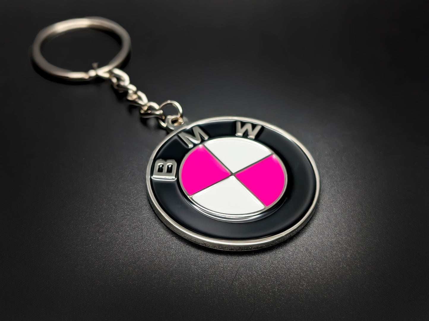 High-quality pink BMW badge keychain on a dark background, showcasing the durable linked chain and vibrant gloss enamel finish.