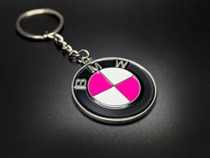 High-quality pink BMW badge keychain on a dark background, showcasing the durable linked chain and vibrant gloss enamel finish.