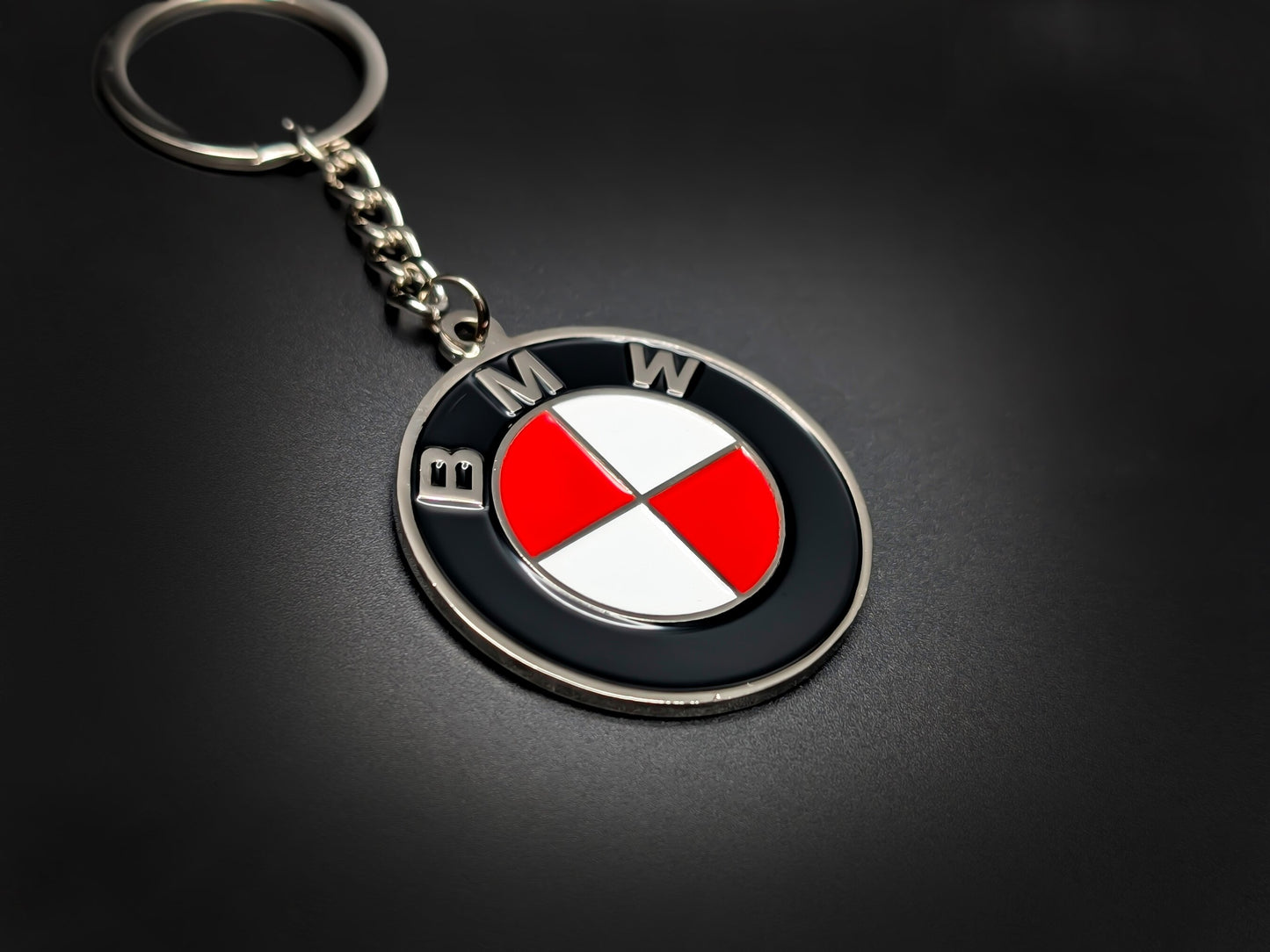 High-quality BMW red heritage roundel keychain on a dark background, showing the glossy finish and sturdy silver link chain.