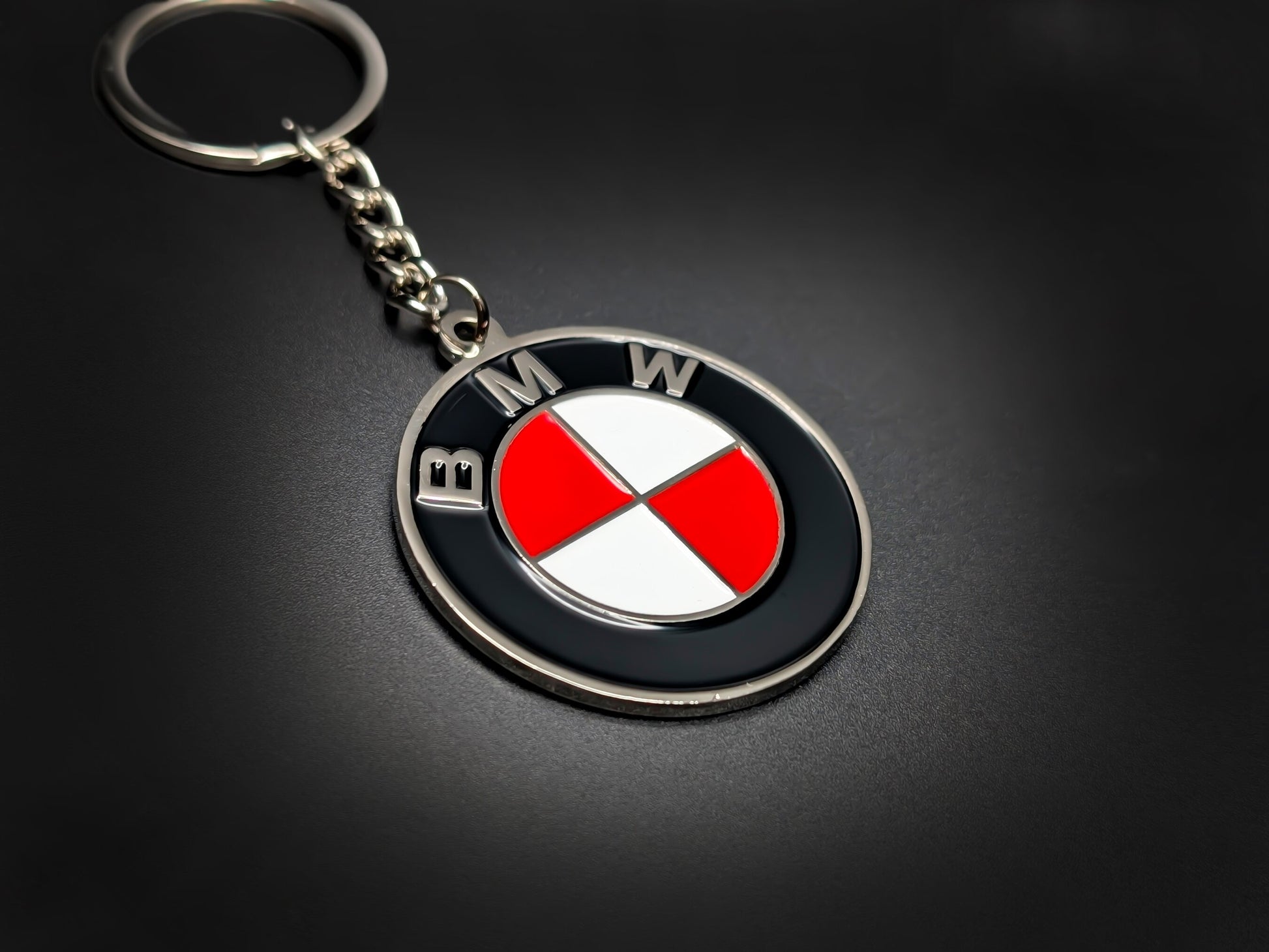 High-quality BMW red heritage roundel keychain on a dark background, showing the glossy finish and sturdy silver link chain.