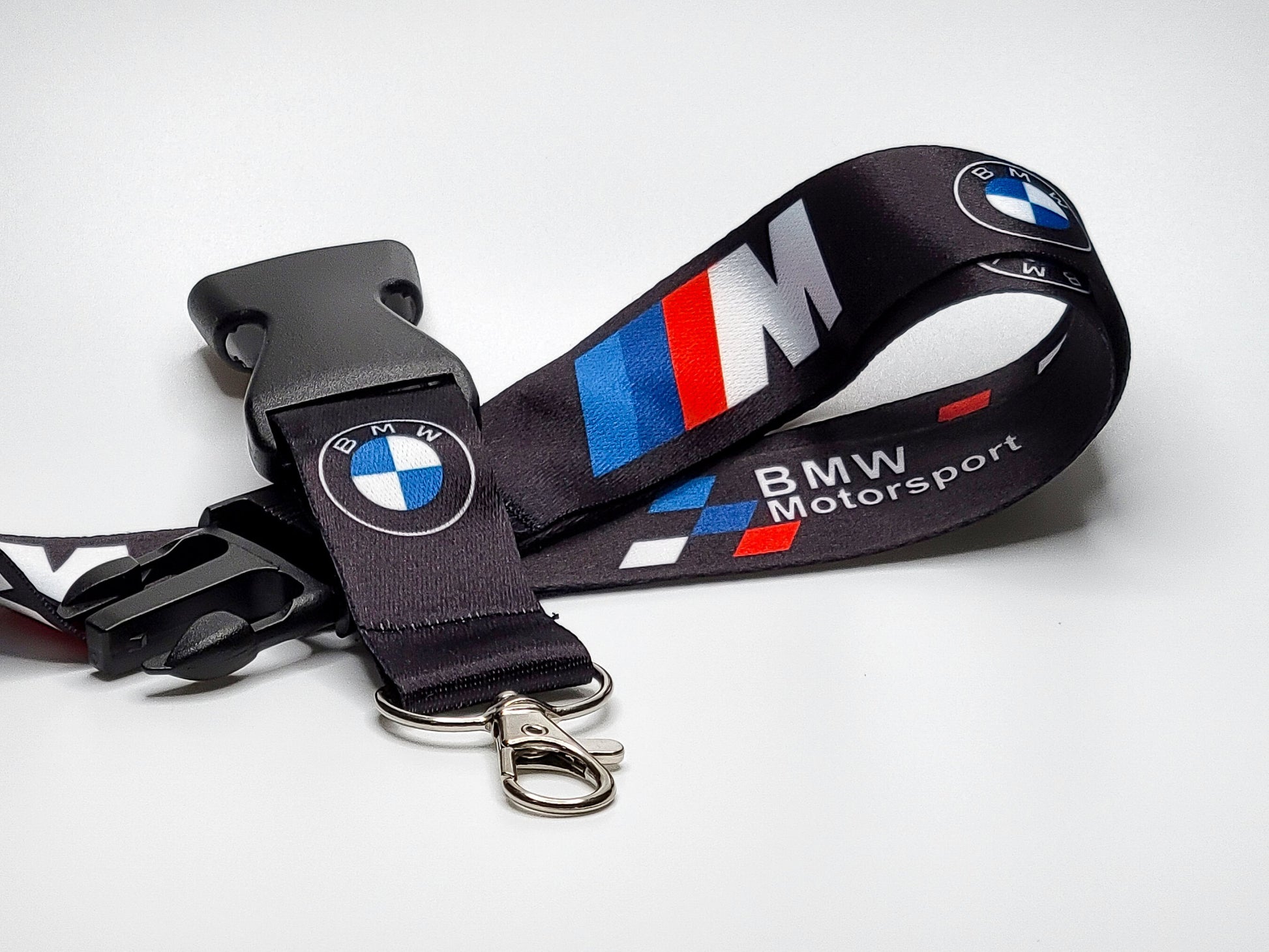 Black BMW Motorsport lanyard with the signature M Power tri-color stripes, BMW roundel logo, and a silver lobster claw metal clasp.