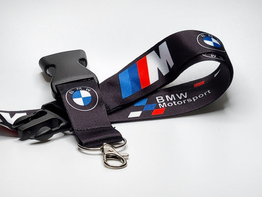 Black BMW Motorsport lanyard with the signature M Power tri-color stripes, BMW roundel logo, and a silver lobster claw metal clasp.