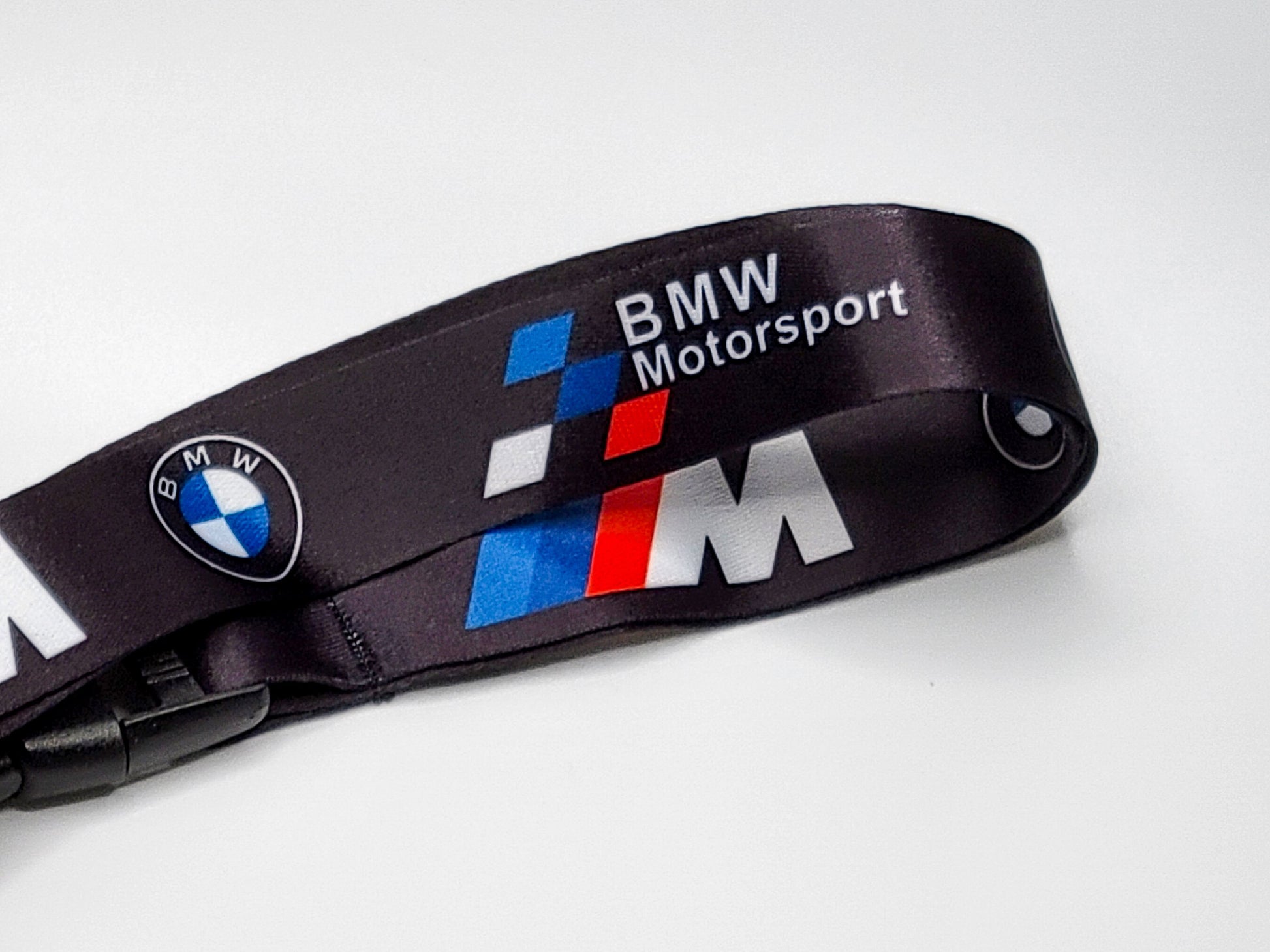 Close-up of a premium satin BMW lanyard highlighting the BMW Motorsport wordmark and the classic M performance blue and red graphics.