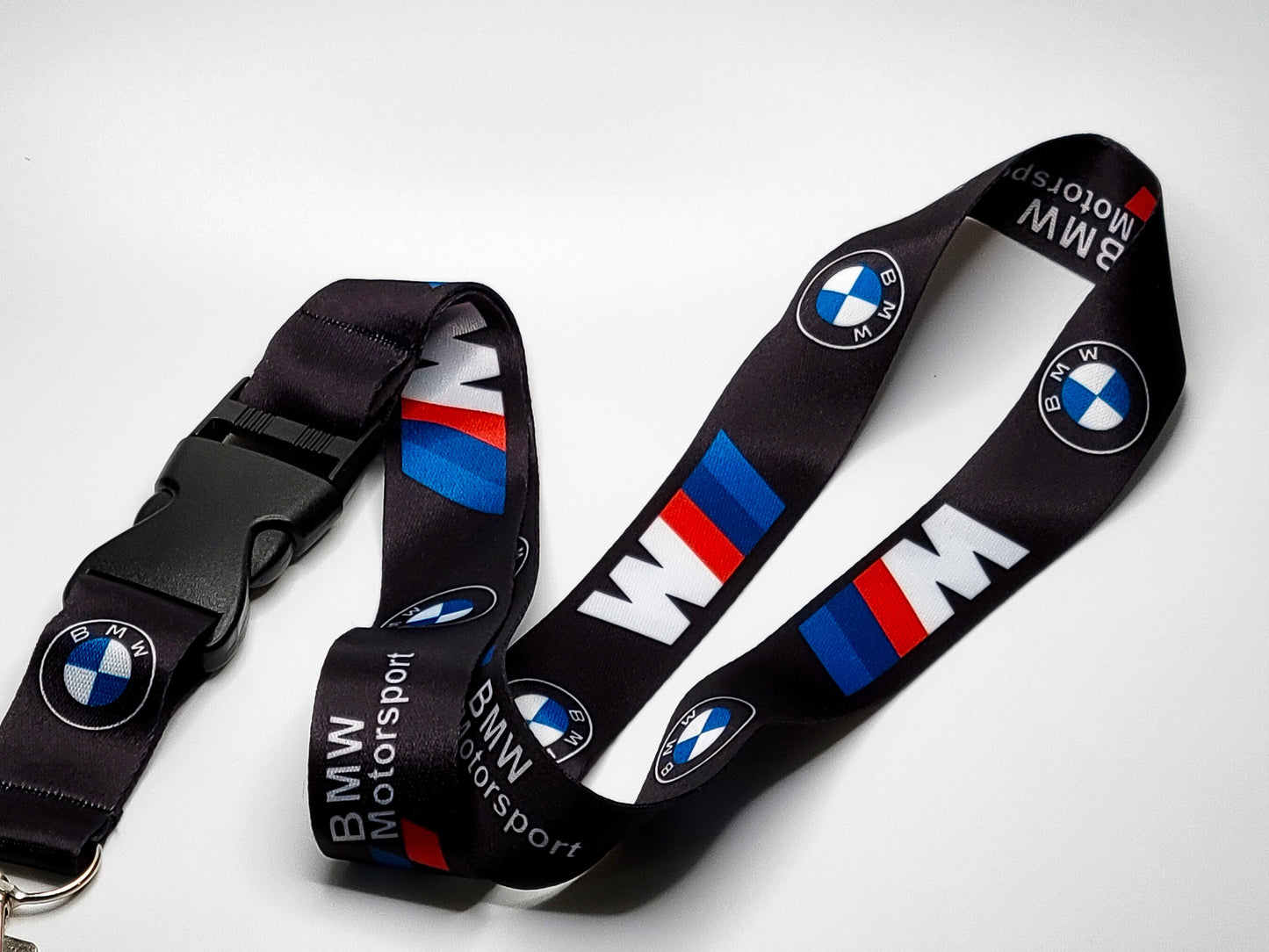 Repeating pattern of the BMW logo and M stripes on a high-quality black neck lanyard with a black detachable plastic buckle.