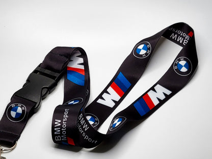 Repeating pattern of the BMW logo and M stripes on a high-quality black neck lanyard with a black detachable plastic buckle.
