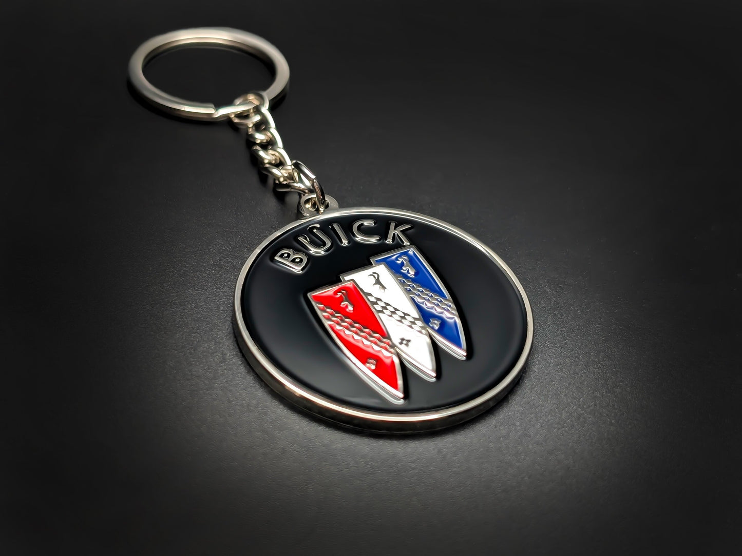 High-quality Buick car badge keychain on a dark background, showcasing the glossy enamel finish and sturdy silver link chain.