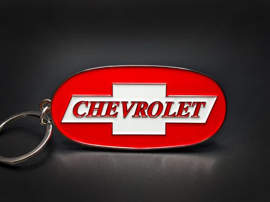 Vintage Chevrolet Trucks badge keychain with a white bowtie logo and red lettering on a vibrant red enamel oval base.