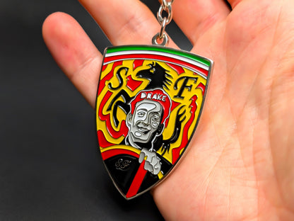 Hand holding a 3D Enzo Ferrari enamel badge keychain to demonstrate the premium metallic weight and vibrant yellow racing colors.