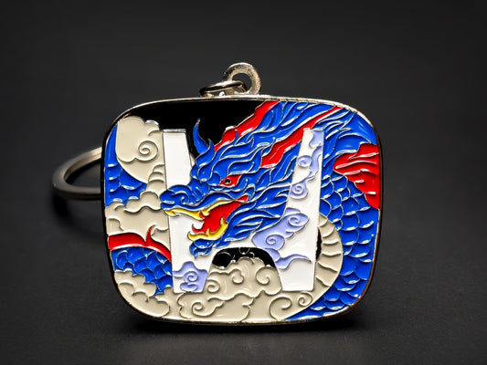 Close-up of a square metal badge keychain featuring a blue and red JDM dragon interwoven with the Honda "H" logo.