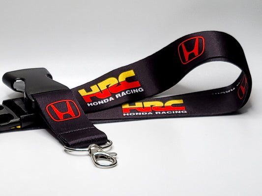 Black Honda Racing lanyard featuring the red HRC logo and yellow "Honda Racing" text, complete with a silver lobster claw clasp.