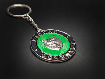 High-gloss Jaguar Coventry heritage badge keychain on a dark surface, showing the polished metallic rim and silver-tone chain.