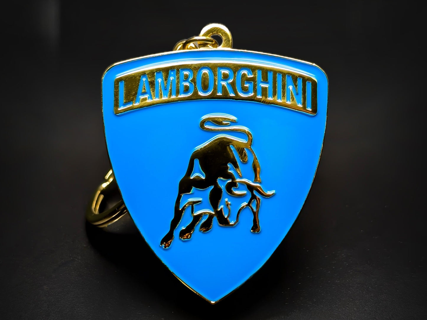Lamborghini shield keychain in electric blue enamel with a gold-plated 3D raging bull and embossed logo.