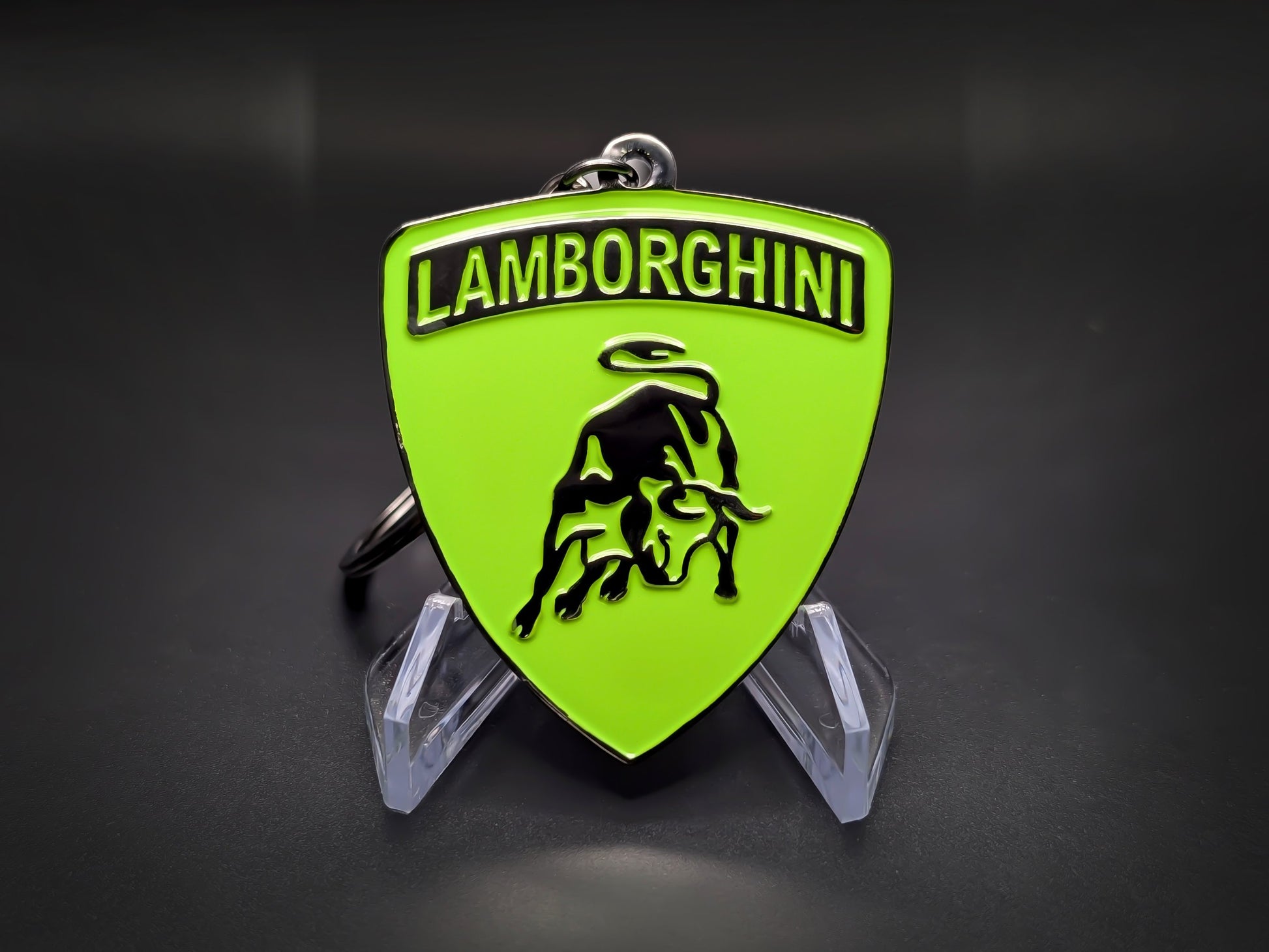 High-gloss green Lamborghini badge keychain on a dark background, showing the polished metallic rim and chain.