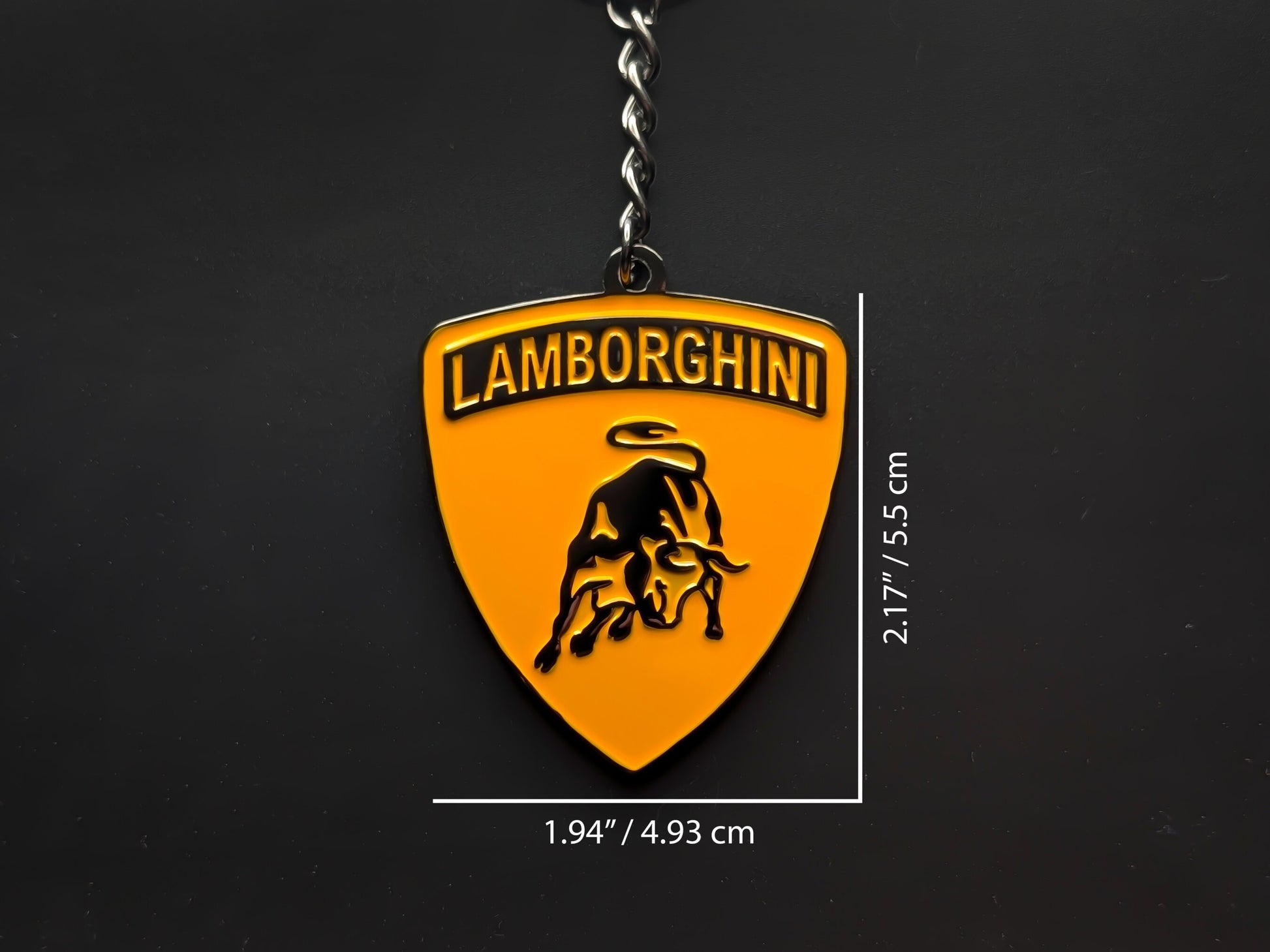 Dimension shot of the Lamborghini orange badge keychain showing a size of 2.17 inches by 1.94 inches (5.5 cm by 4.93 cm).