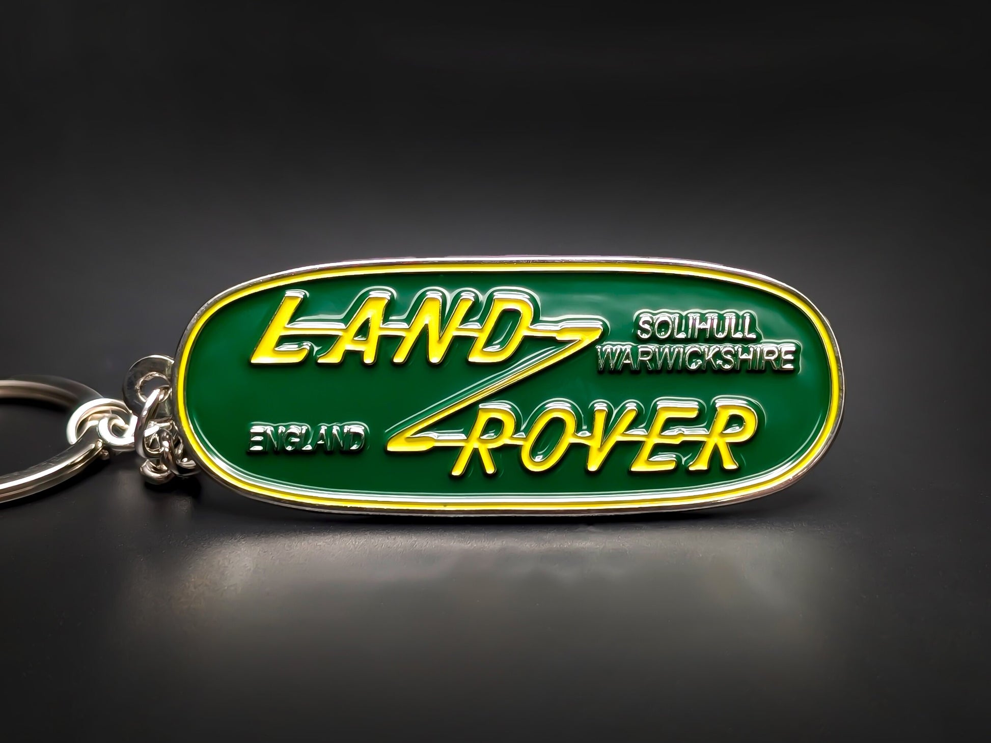 Vintage Land Rover badge keychain in green and yellow enamel, featuring Solihull, Warwickshire and England text.