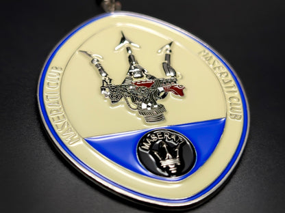 Close-up of the Maserati Club keychain, highlighting the intricate 3D trident logo and small Maserati emblem at the base.