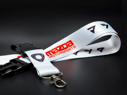 White Mazda Motorsports lanyard featuring a black rotary engine housing logo, red branding, and a silver lobster claw metal clasp.