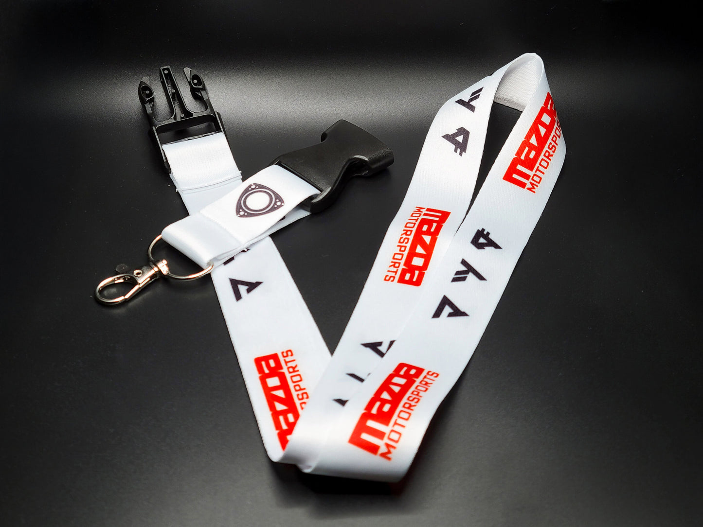 Full layout of a Mazda racing lanyard with its black quick-release plastic buckle and durable metal attachment for keys or ID badges.