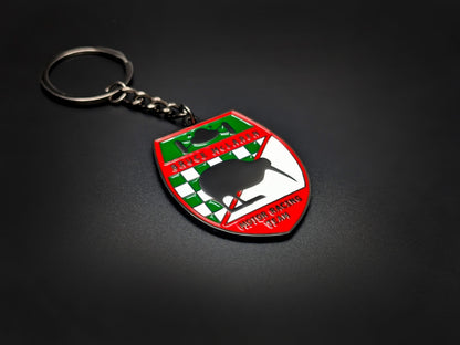 High-quality retro McLaren racing keychain on a dark background, showcasing the vibrant red border and durable gunmetal-finish chain.