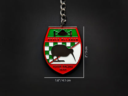 Dimension shot of the Bruce McLaren vintage badge keychain showing a size of 2 inches by 1.6 inches (5 cm by 4.1 cm).