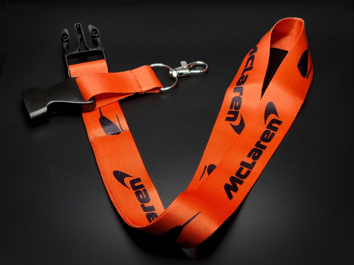 McLaren orange lanyard with a black quick-release plastic buckle and durable metal lobster claw attachment for keys.