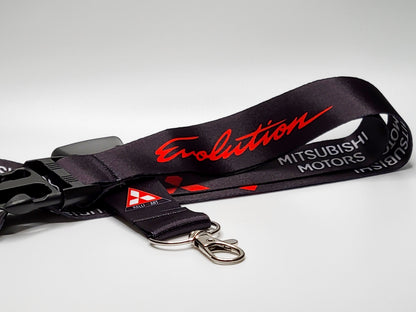 Black Mitsubishi Evolution lanyard featuring red script lettering, white Mitsubishi Motors text, and a Ralliart logo near a silver metal clasp.