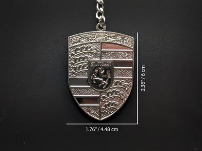 Dimensions of the Porsche silver badge keychain showing a size of 2.36 inches by 1.76 inches (6 cm by 4.48 cm).