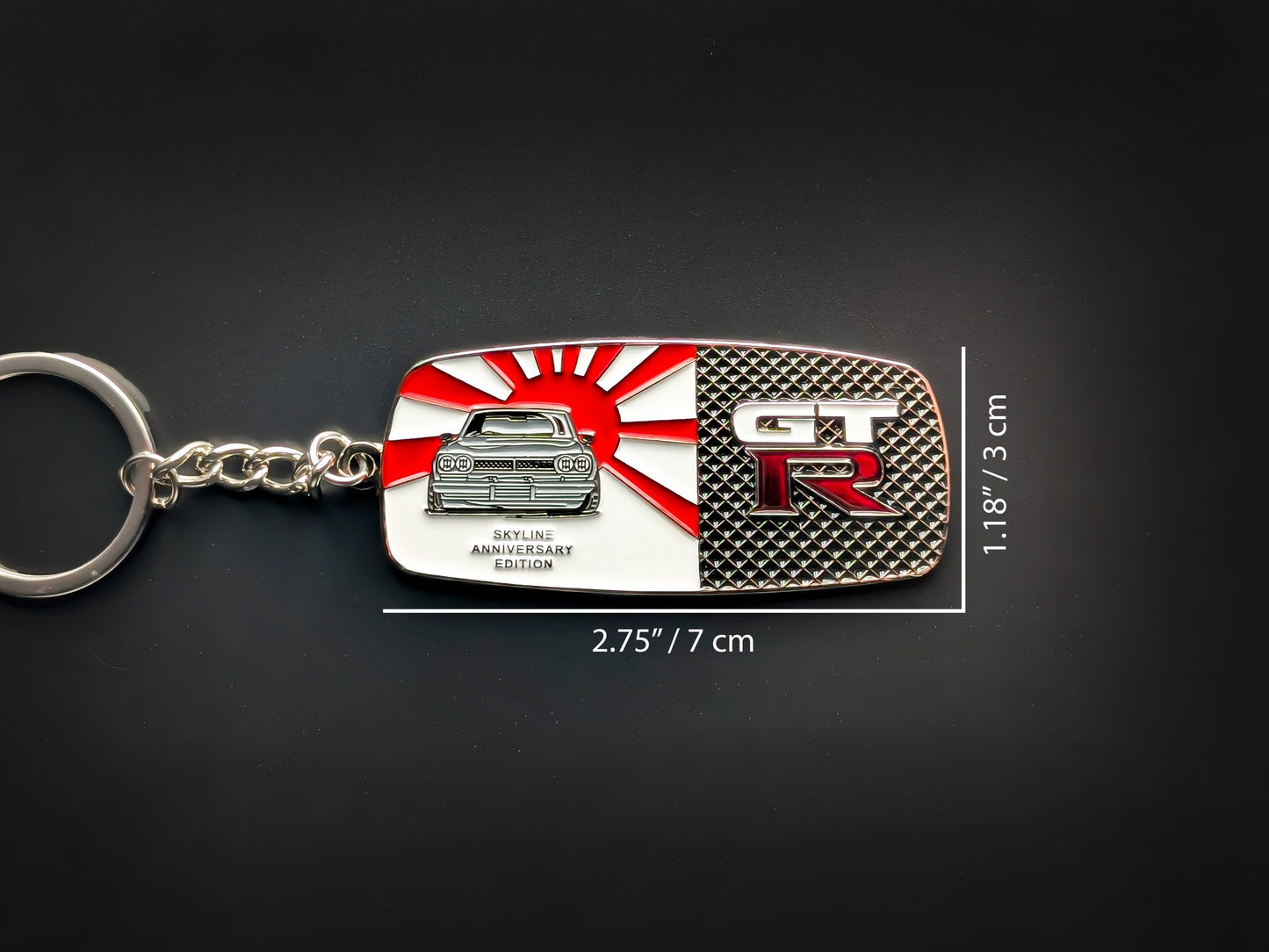 Dimension shot of the Skyline GT-R badge keychain showing a size of 2.75 inches by 1.18 inches (7 cm by 3 cm).