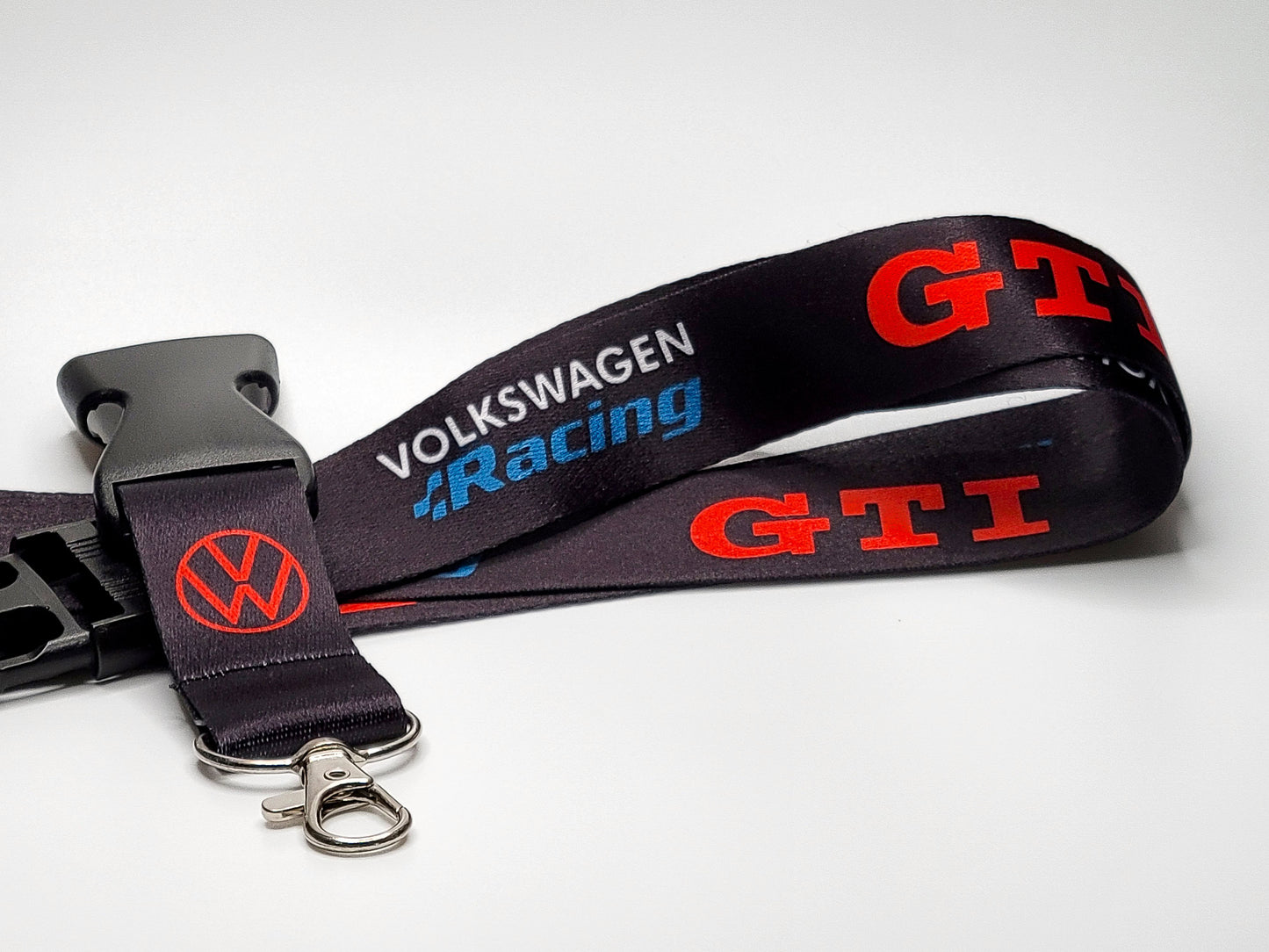 Black Volkswagen lanyard featuring red GTI block lettering, a blue Volkswagen Racing logo, and a silver lobster claw metal clasp.